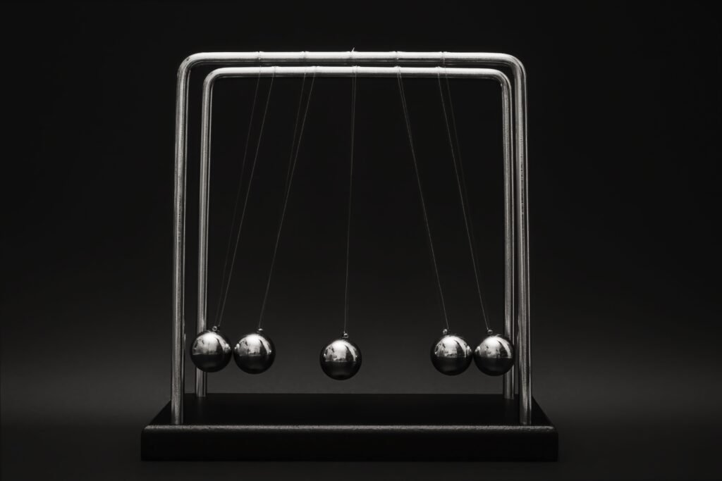 Newton's cradle for physics principles and motion study on a dark background.